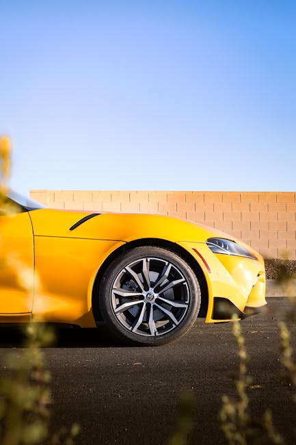 Luxury Cars - A sleek yellow sports car against a blue sky, sh #33165882