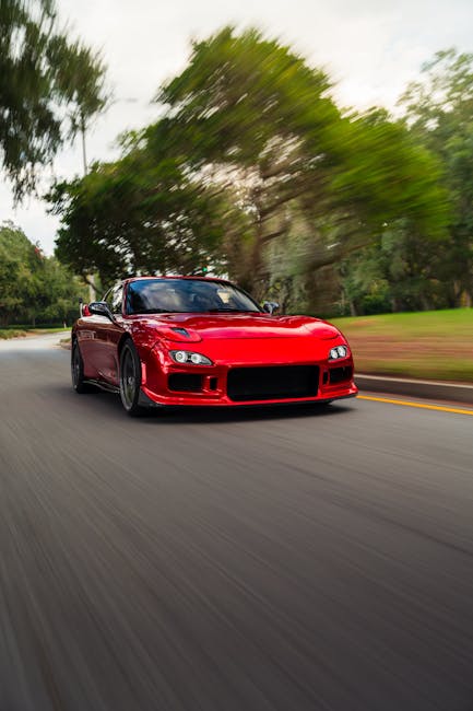 Luxury Cars - Dynamic shot of a red sports car racing along a #34911547