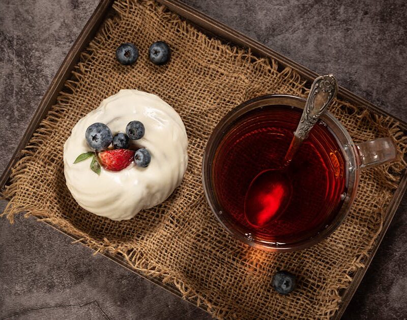 Food Aesthetics - Top view of a berry-topped cake and glass of tea #7332982